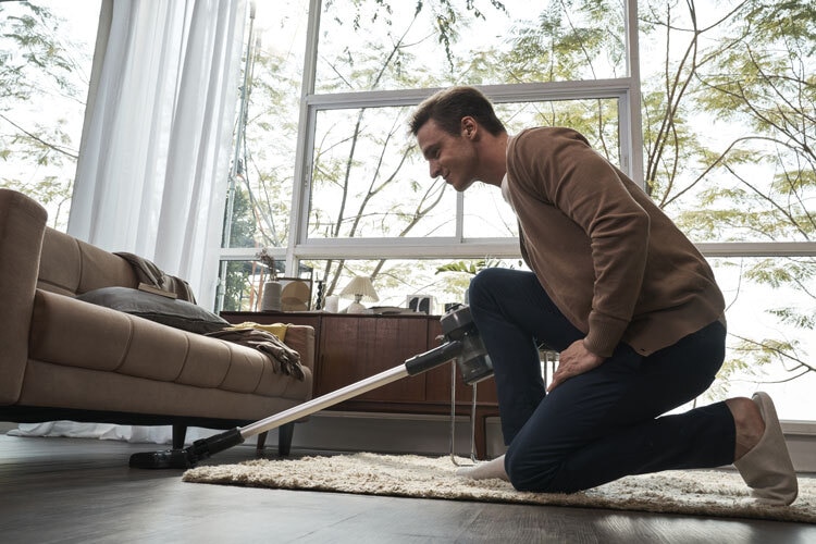 vacuuming under sofa